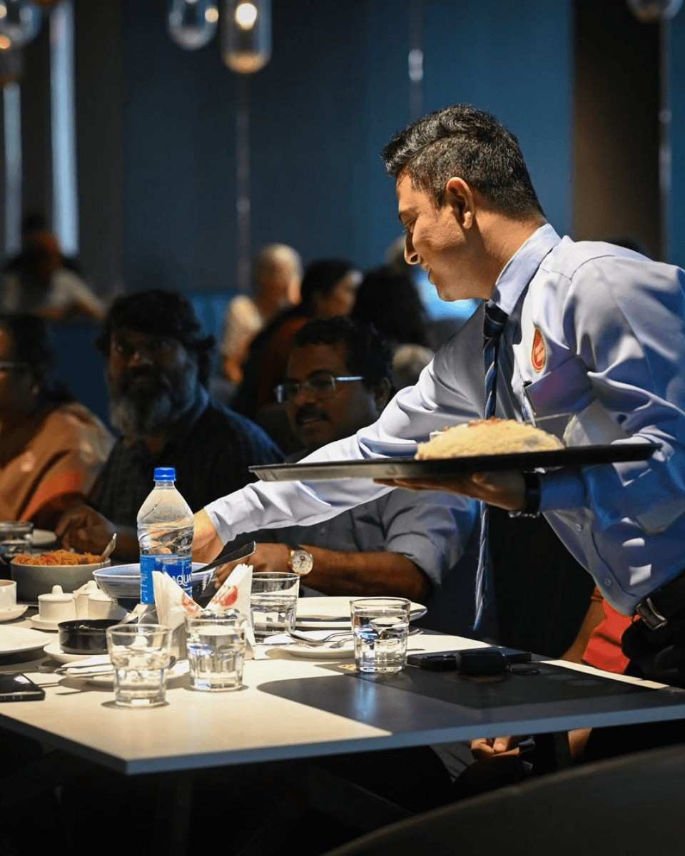 Server bringing food to guests at an Imperial Kitchen banquet in Trivandrum
